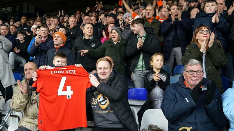 Luton Town fans take part in a minutes applause in...
