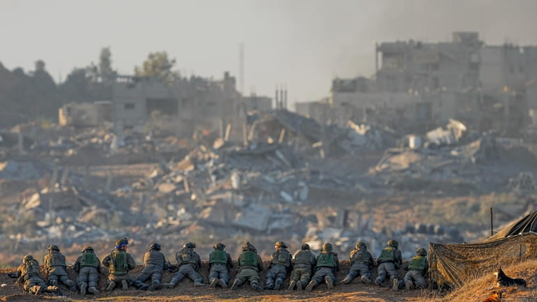 Israeli soldiers take positions near the Gaza Strip border, in...