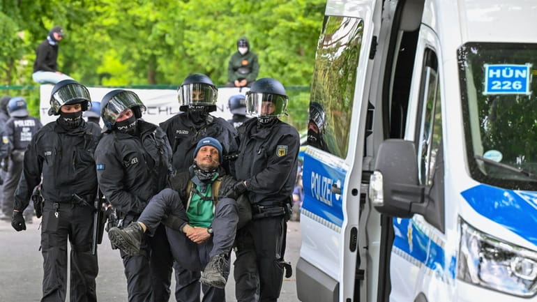 Police carry a activist from a blocade, at the access...
