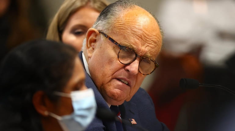 Rudy Giuliani listens to Detroit poll worker Jessi Jacobs during...