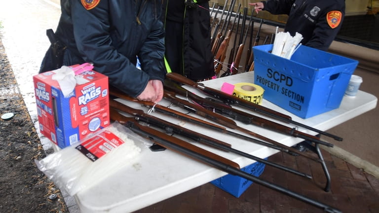 Suffolk police inspect and tag firearms turned in at a gun buyback...