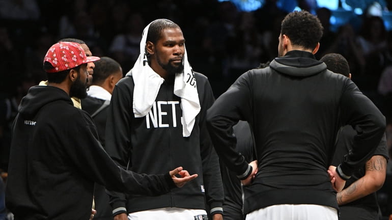 Nets' Kyrie Irving, Kevin Durant and Ben Simmons talk during...