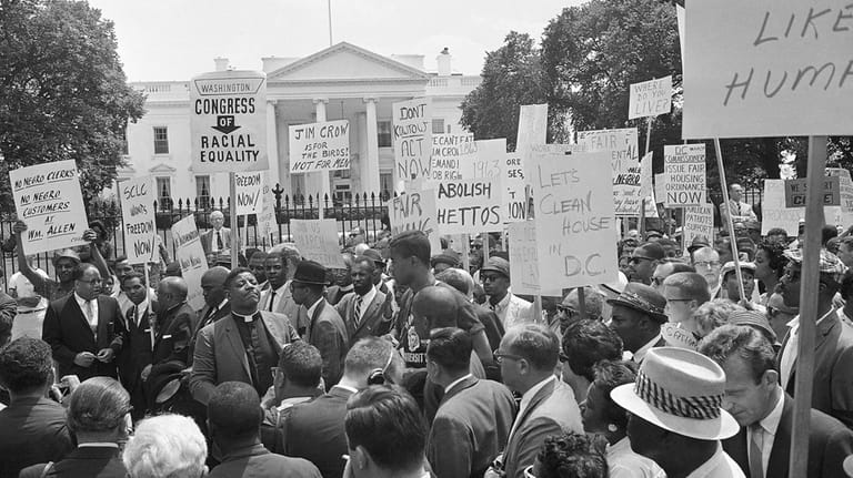 A group of demonstrators pause in front of the White...