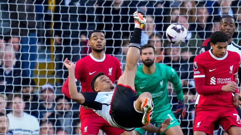 Fulham's Rodrigo Muniz, center, kicks the ball during the English...