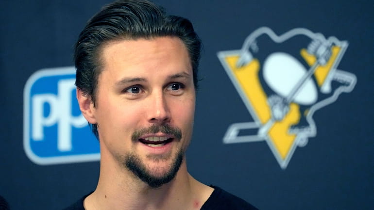 Newly acquired Pittsburgh Penguins defenseman Erik Karlsson holds his first...