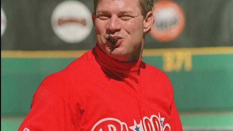 Philadelphia Phillies centerfielder Lenny Dykstra enjoys a mouthful of chewing...