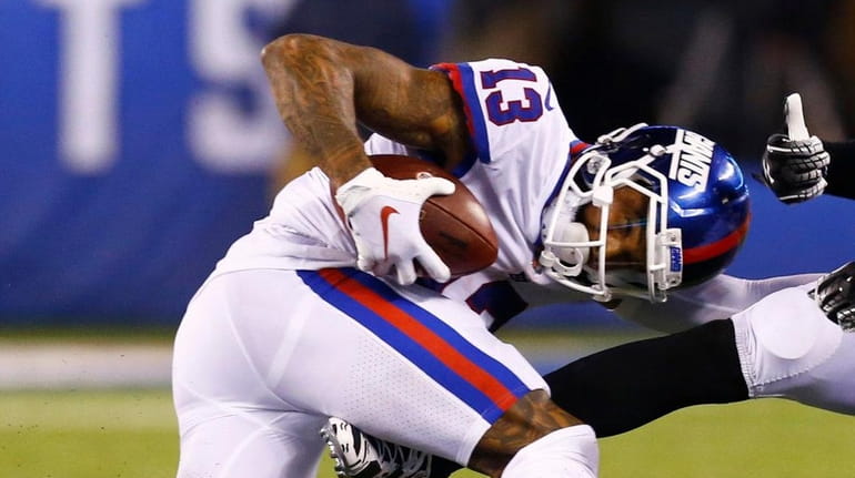 Odell Beckham Jr. of the Giants is tackled by Malcolm...