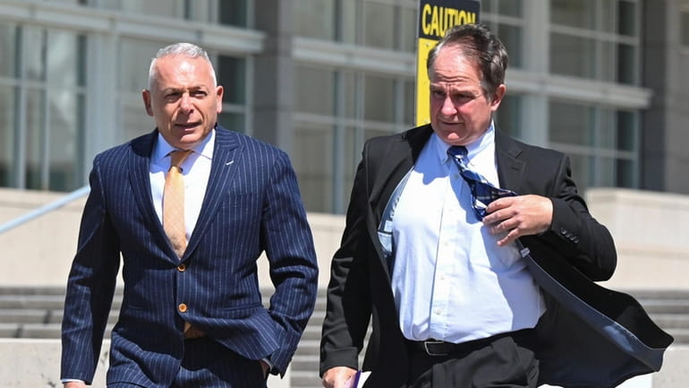 Gregory Settino, right, of Bethpage, leaves federal court in Central...