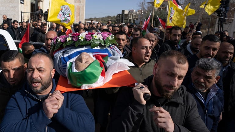 Mourners carry the body of Omar Assad, during his funeral...