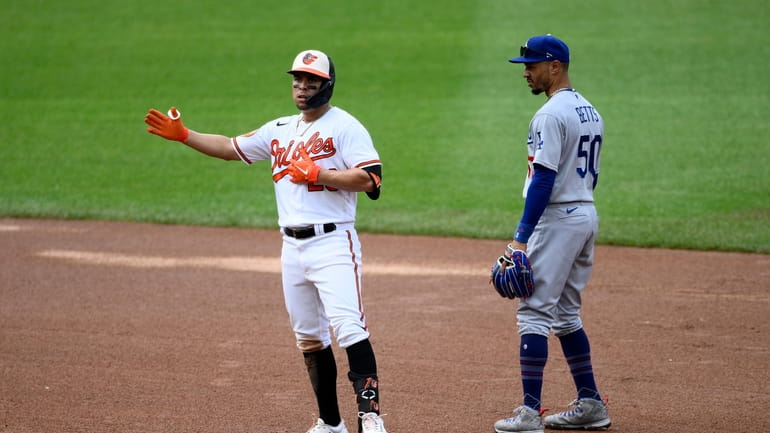 Baltimore Orioles' Ramon Urias, left, gestures as he stands on...