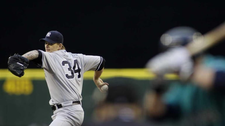 Yankees starting pitcher A.J. Burnett throws against the Mariners in...