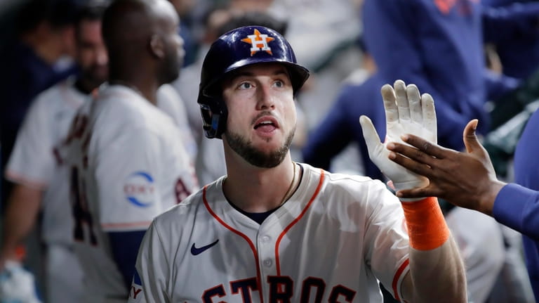 Houston Astros Kyle Tucker collects high fives in the dugout...