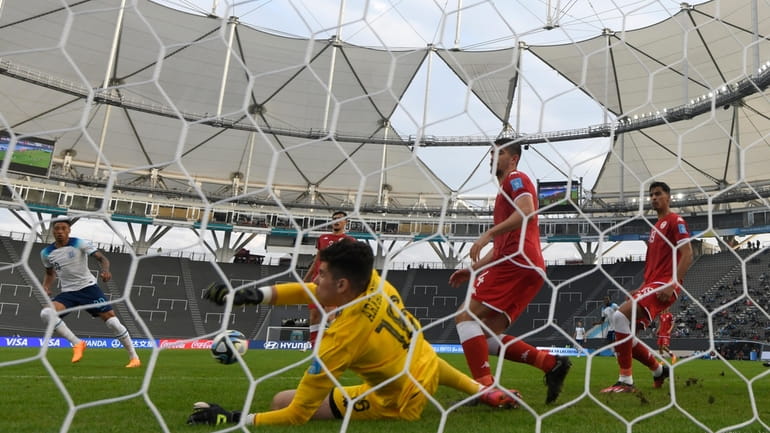 Tunisia's goalkeeper Dries Arfaoui, center, blocks a shot by England's...