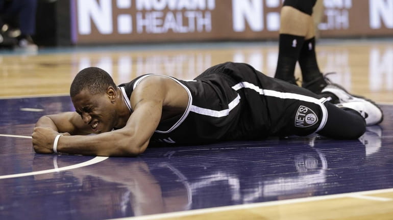 The Brooklyn Nets' Thaddeus Young lays on the court after...