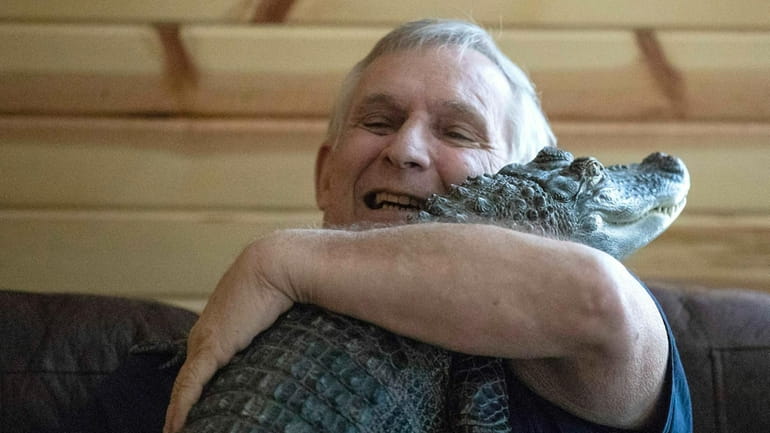 Joie Henney hugs his emotional support alligator named Wally, Jan....