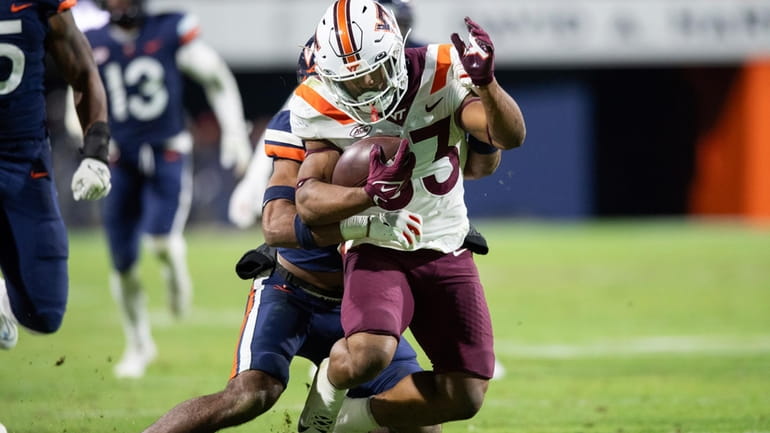 Virginia Tech running back Bhayshul Tuten (33) is tackled by...
