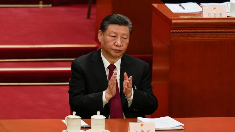 Chinese President Xi Jinping applauds during the opening session of...