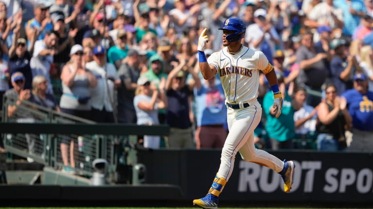Seattle Mariners' Julio Rodriguez jogs the bases after hitting a...