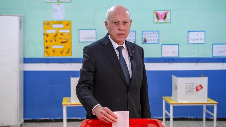 Tunisia's President Kais Saied casts his ballot as he participates...
