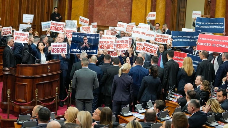 Opposition lawmakers hold banners reading: "Stole the elections" during a...