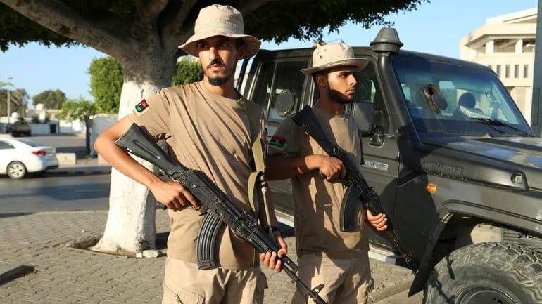 Libyan security forces stand guard in Tripoli, Libya, Tuesday, Aug....