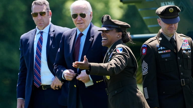 President Joe Biden, second left, is greeted as he walks...