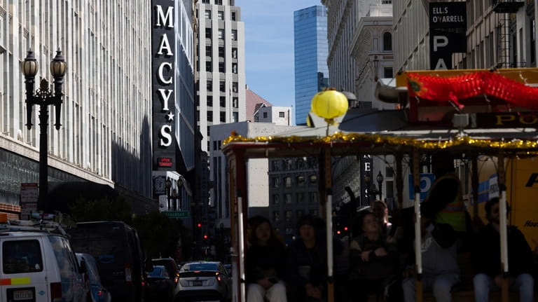 A cable car traveling along Powell Street passes Macy's near...