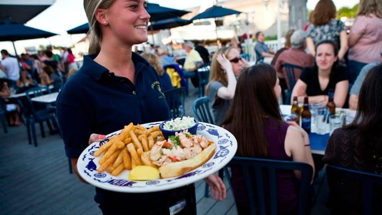 A waitress carries a lobster roll platter at The Fishery...
