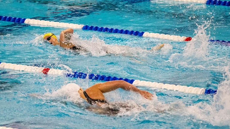 Summer McIntosh, top, competes against Katie Ledecky in the 400-meter...