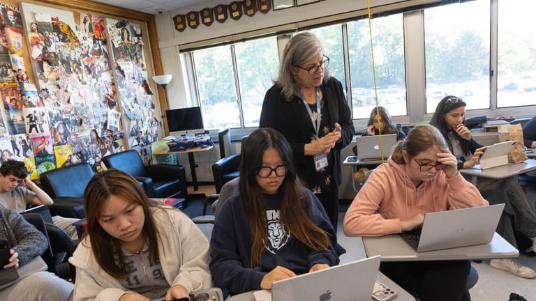 English teacher Suzanne Valenza helps students, from left, Sherry Wang, Sophia Liu and Emma...