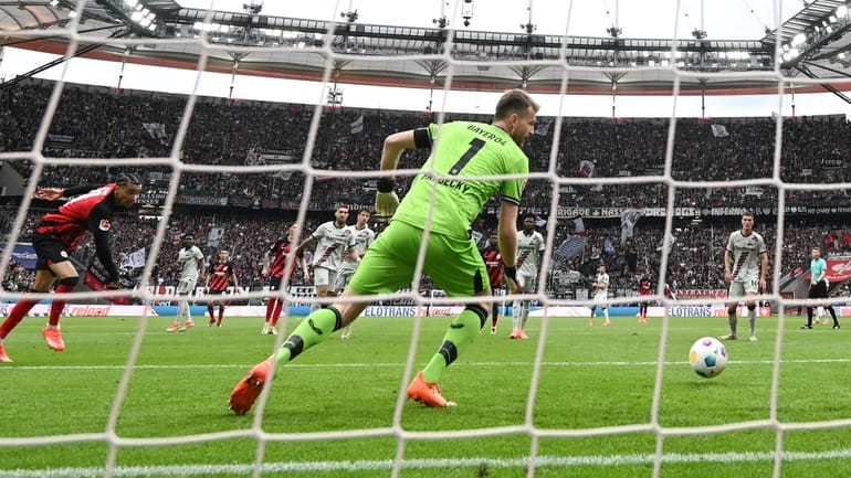 Eintracht Frankfurt's Hugo Ekitik', left, scores the goal to make...