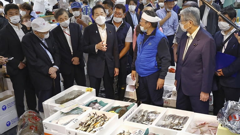 Japan's Prime Minister Fumio Kishida, center, inspects Toyosu fish market...