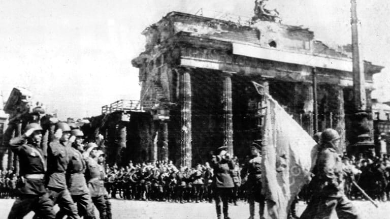 Soviet troops march past the Brandenburg Gate in Berlin, May...