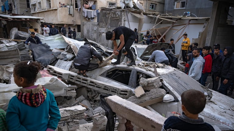 FILE Palestinians inspect a house after it was hit by...