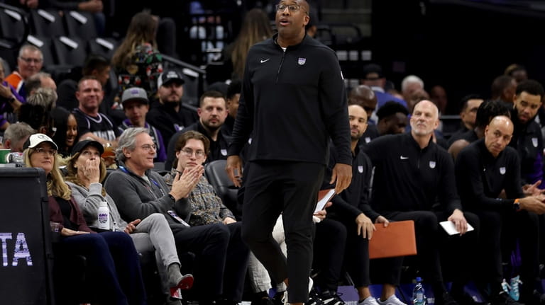 Sacramento Kings head coach Mike Brown, center, yells to his...