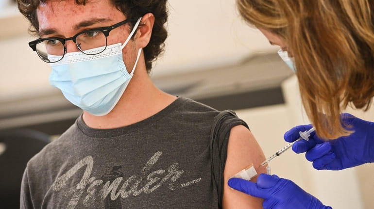 Nicholas Dziedziech, 18, of Freeport, gets the vaccine Thursday as...
