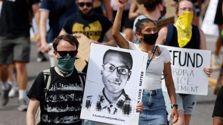 A demonstrator carries an image of Elijah McClain during a...