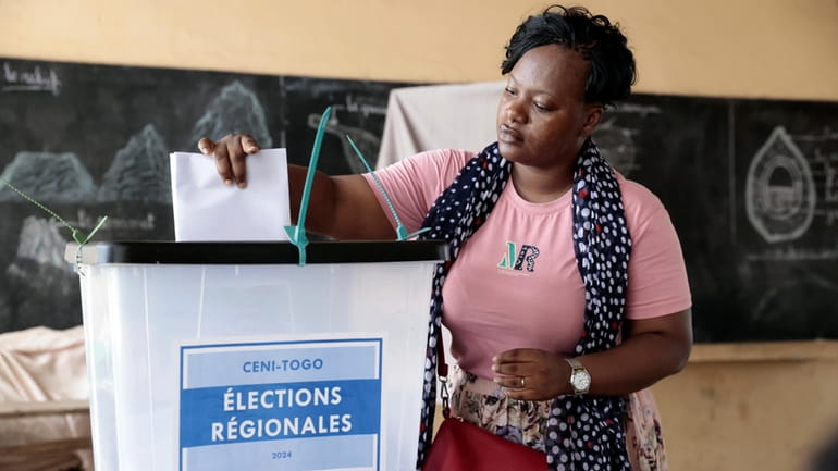 A voter casts her ballot in Togo's regional elections in...