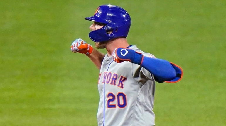The Mets' Pete Alonso celebrates after hitting a three-run double...