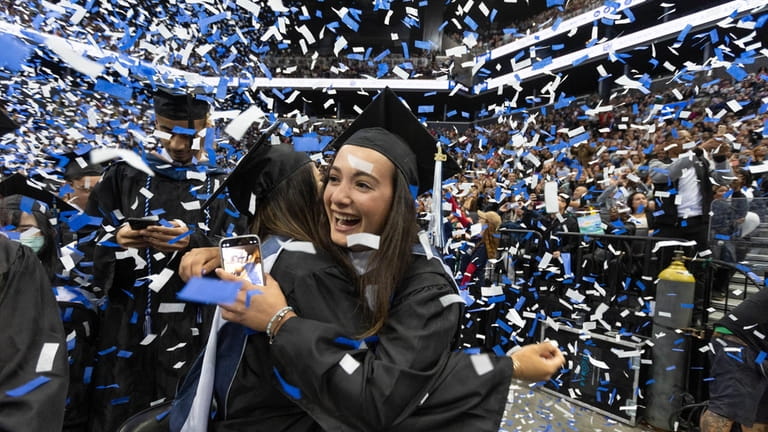 Julia Cuttone hugs Fernanda Zamora at Baruch College graduation ceremonies at...