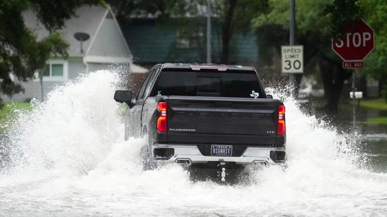 A truck drives through flood water in North Woodland Hills...