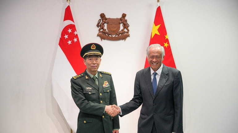 Chinese Defense Minister Gen. Li Shangfu, left, shakes hands with...