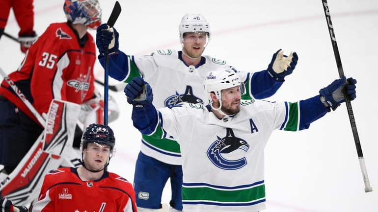 Vancouver Canucks center J.T. Miller, front right, celebrates after his...
