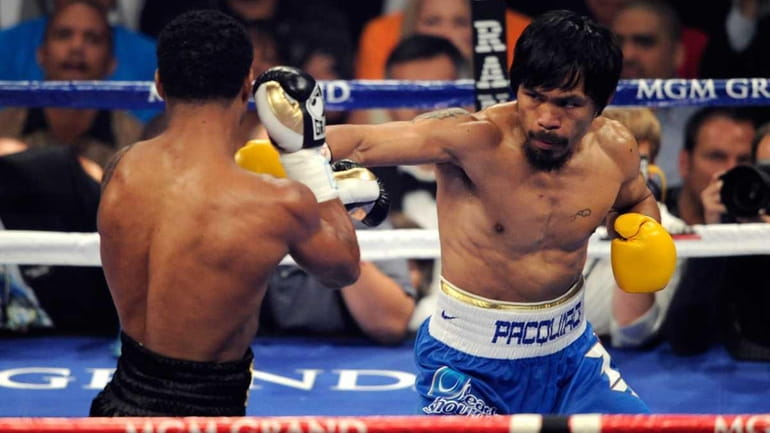 Manny Pacquiao throws a right at Shane Mosley during their...