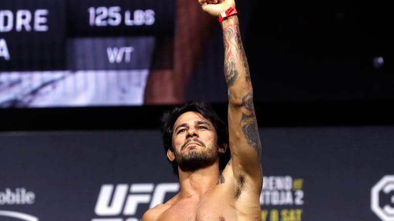 Alexandre Pantoja poses on the scale during a ceremonial weigh-in...