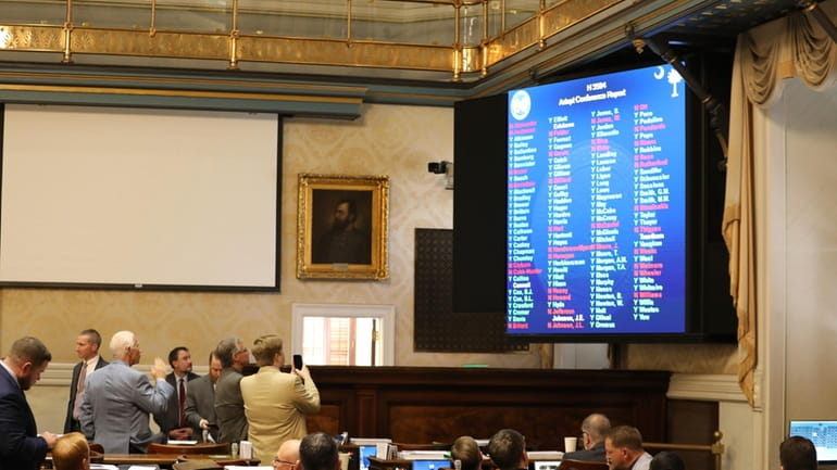 South Carolina House members watch the voting board as the...