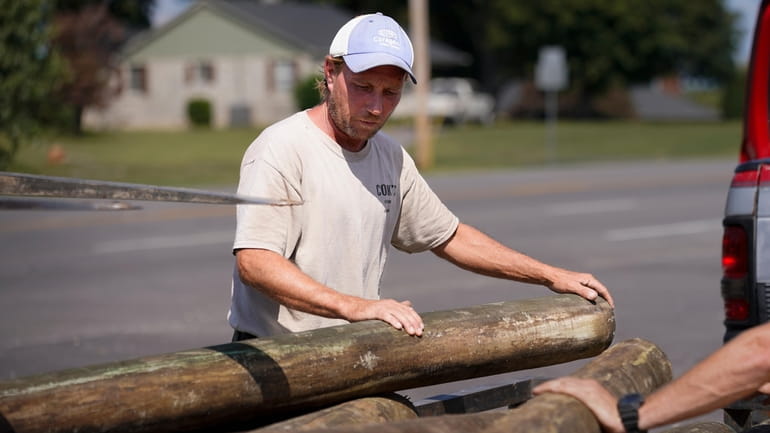 Mark Cook loads lumber onto a trailer, Tuesday, Oct. 3,...