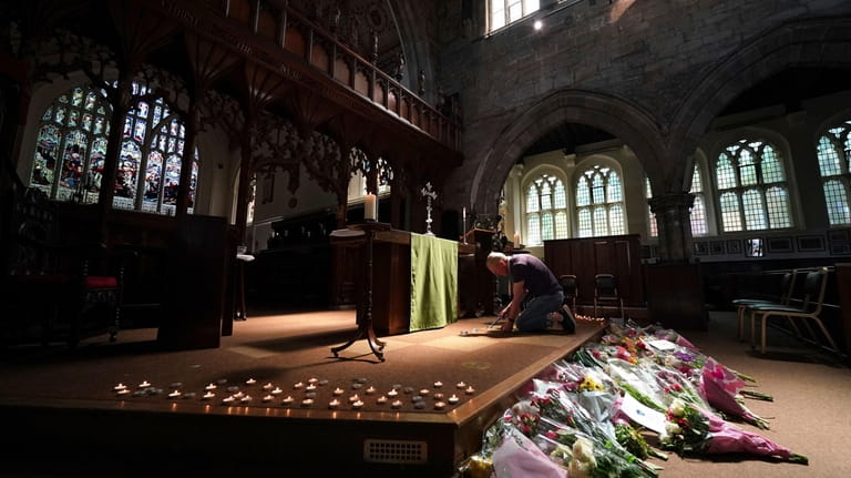 A man lights a candle in St Peter's church, after...