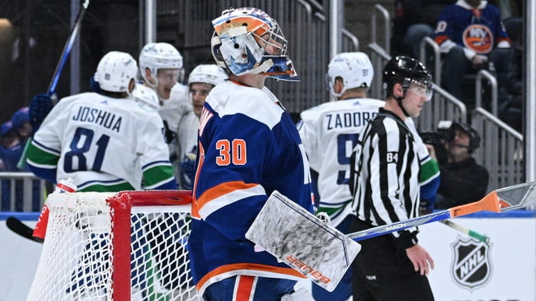 Islanders goaltender Ilya Sorokin reacts as the Canucks celebrate a...