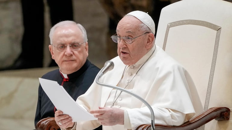 Pope Francis, front, delivers his speech during his weekly general...